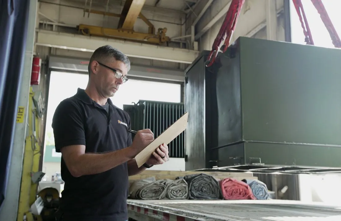 Maddox worker supervising the loading of a transformer before it's shipped to a customer
