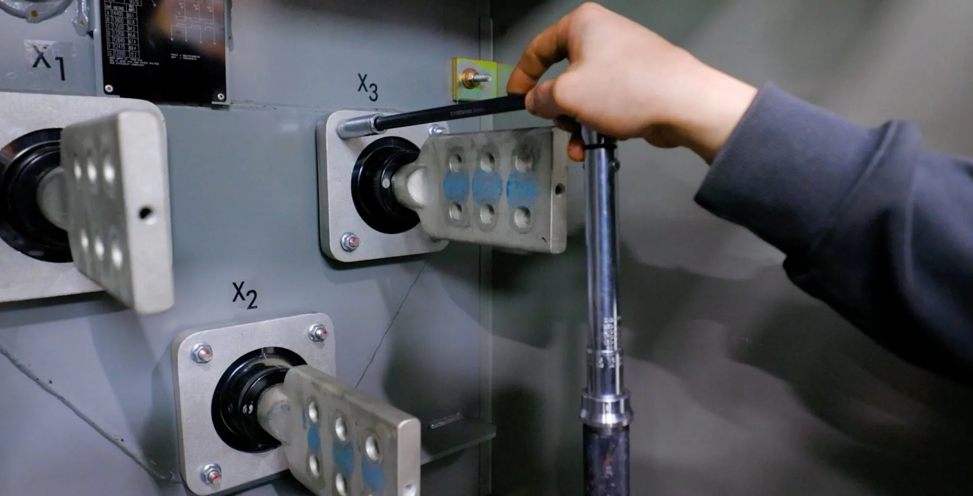 A transformer bushing being torqued correctly to prevent leaks in the gasket