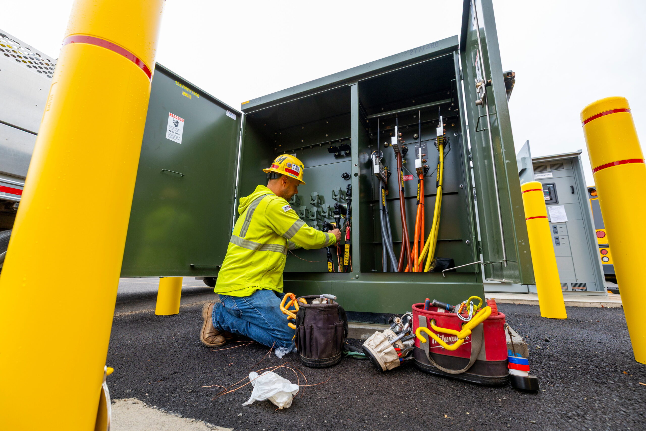 Tech installing padmount for EV bus charging stations