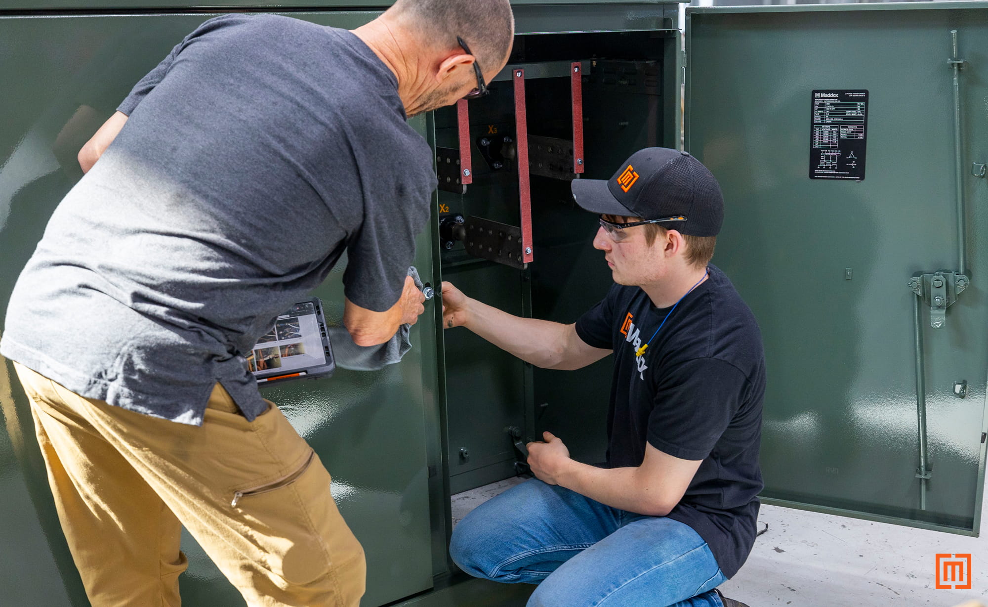 photo of Maddox employees performing maintenance on a padmount transformer