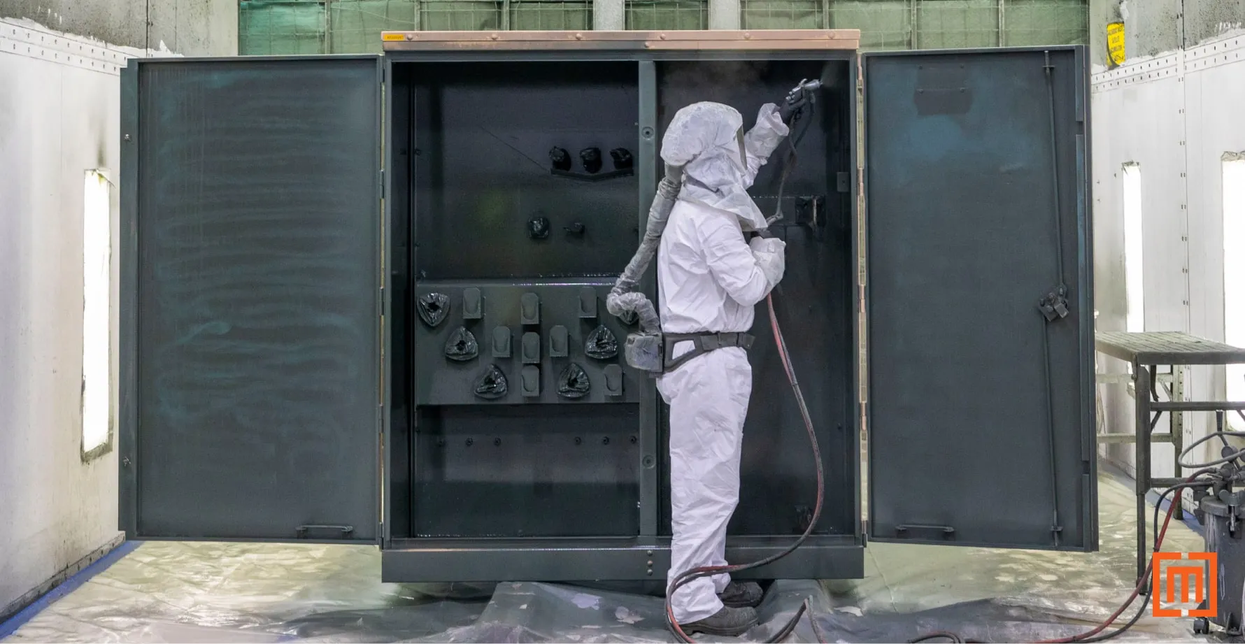 Maddox transformer technician sprays padmount with TransArmour coating