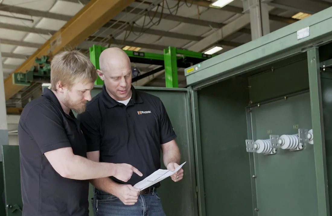 Two Maddox shop workers examine an order to determine the unit specs and necessary parts