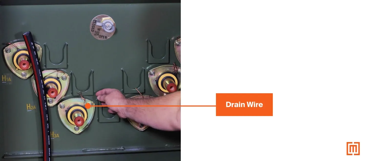 Image showing a drain wire connected to a bushing insert on a radial feed transformer