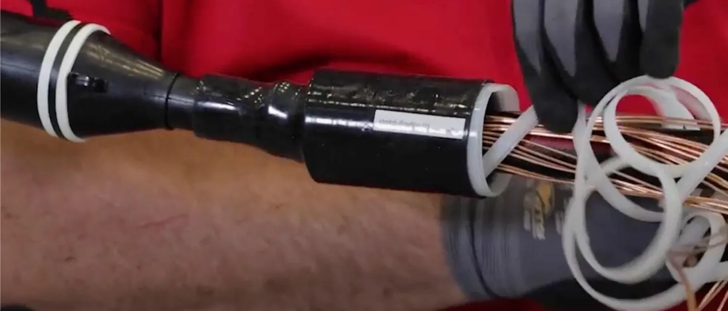 Technician seals cables and insulation in a rubber jacket
