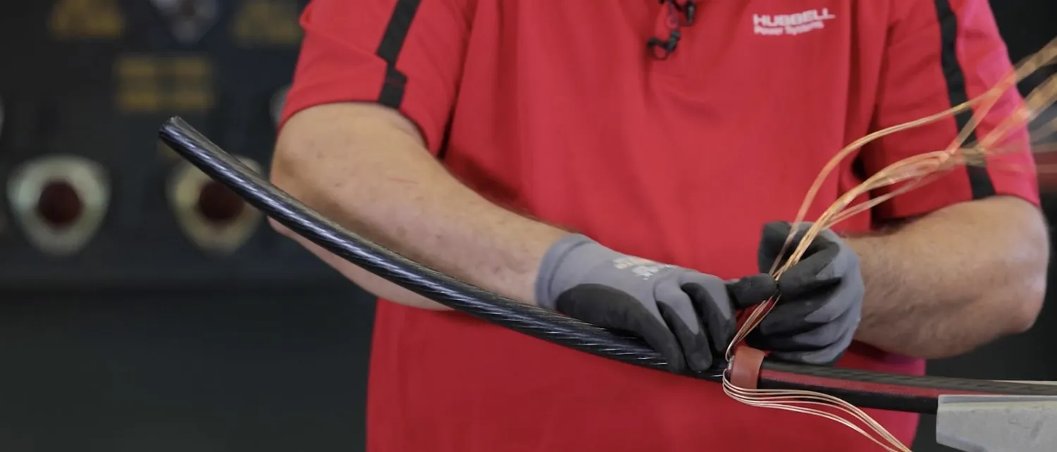 Technician folds concentric neutral cables back to the mastic tape