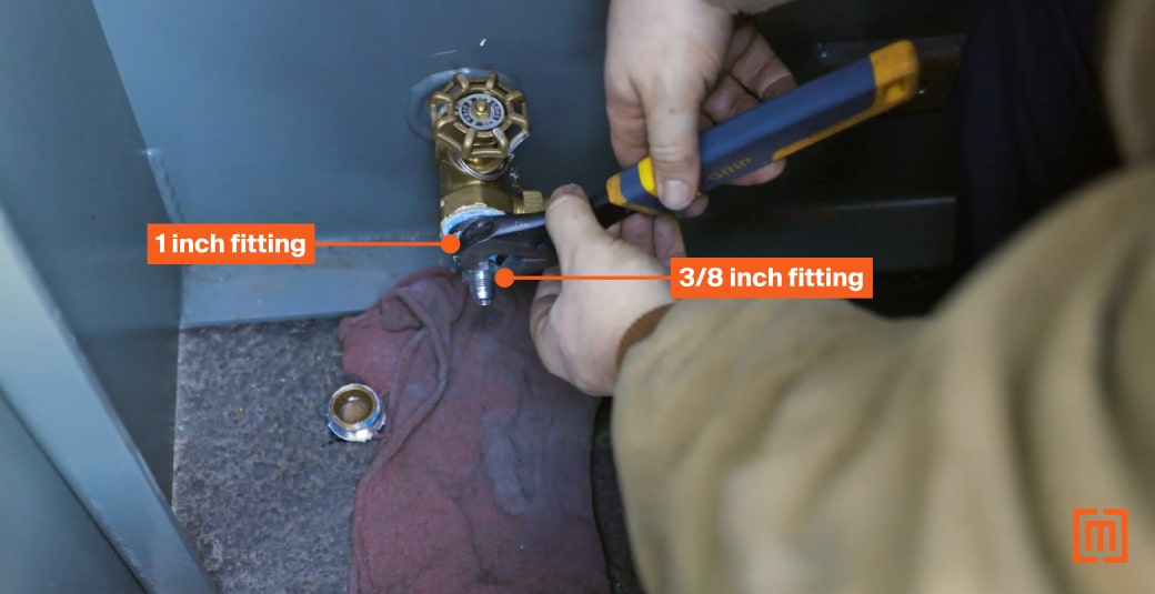 Mechanic tightening one inch and three eights inch fittings transformer cabinet