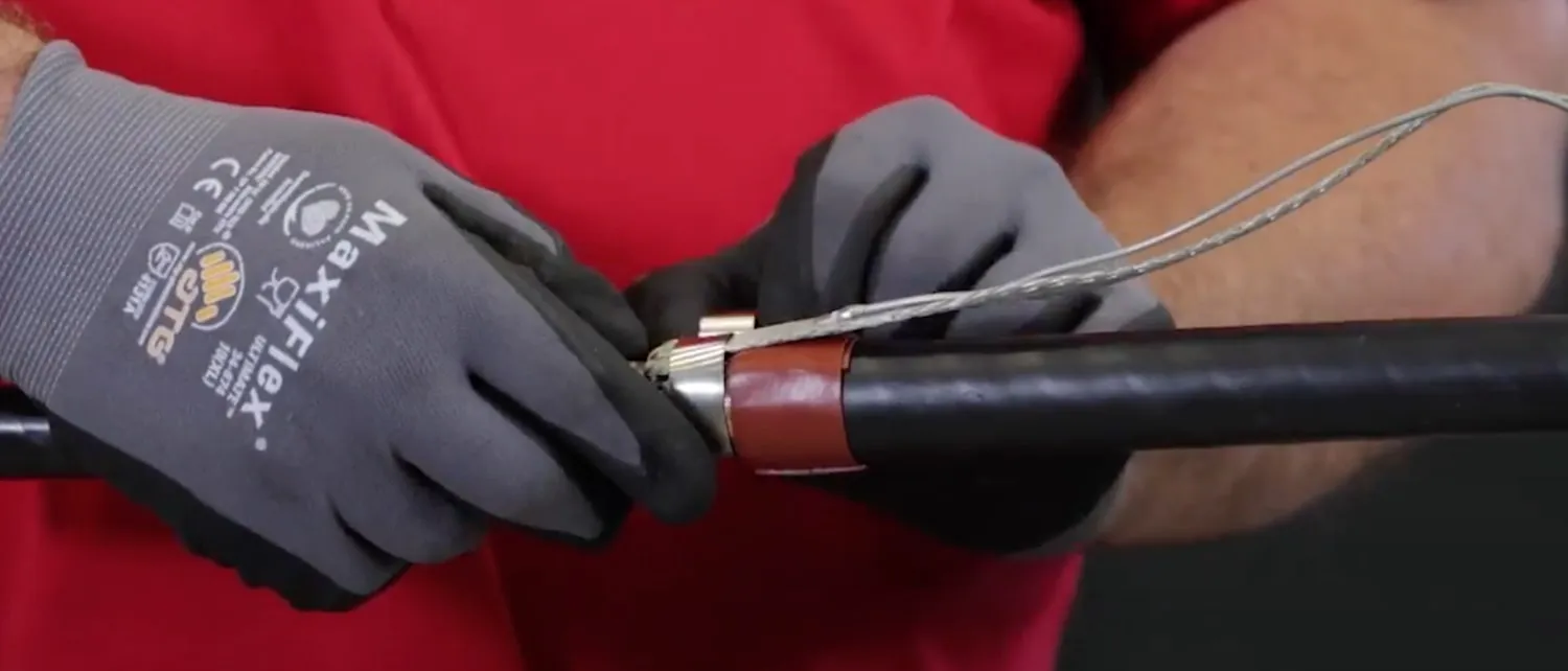 Technician applies the shield adapter kit to copper tape shielded cable