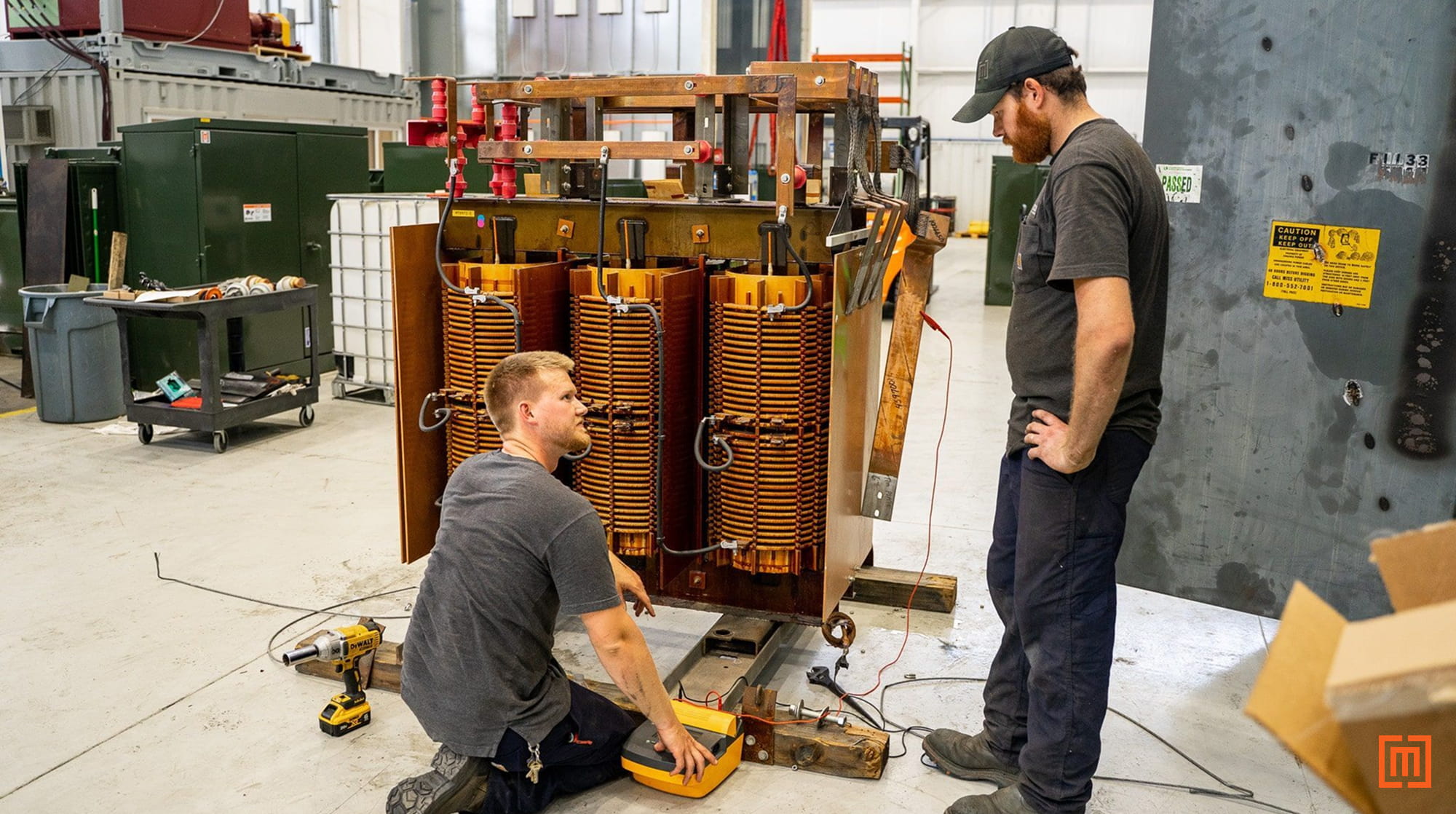 Workers performing a Megger transformer test on a dry-type transformer