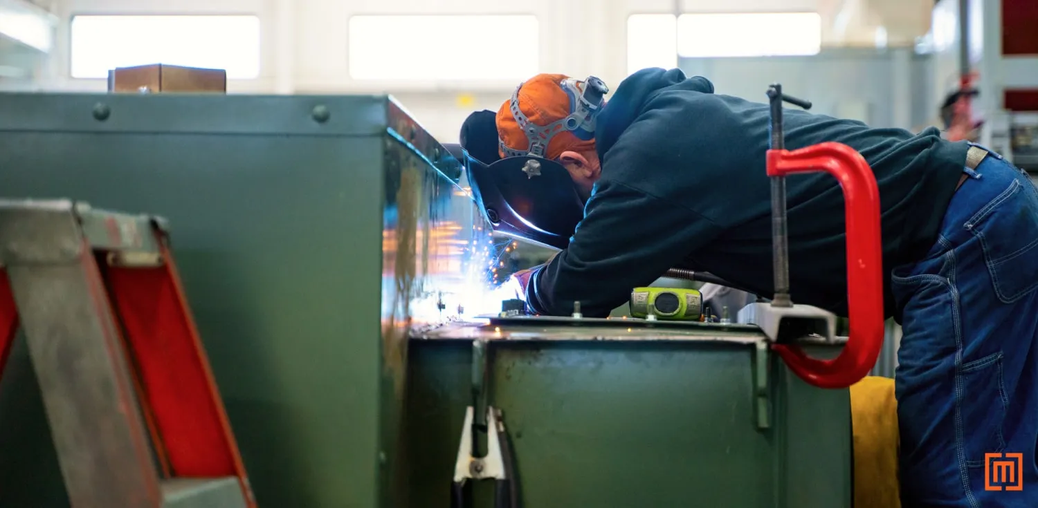 Technician welding on the top side of a padmount