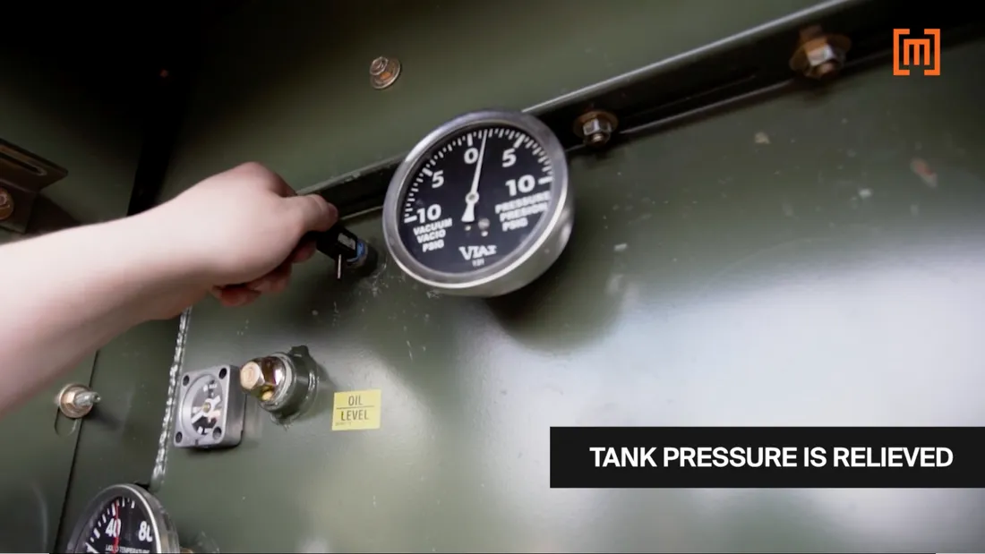 A technician releasing pressure from a padmount transformer tank before taking a DGA oil test