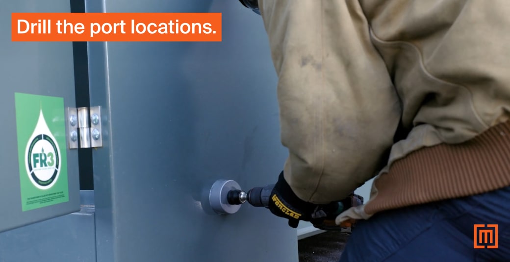 Mechanic drilling hole in transformer cabinet exterior