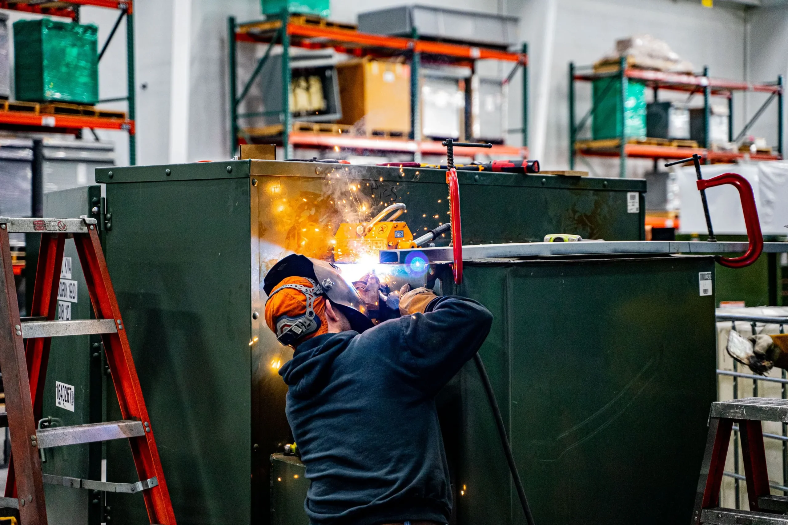 Maddox transformer technician reconditioning a green padmount transformer