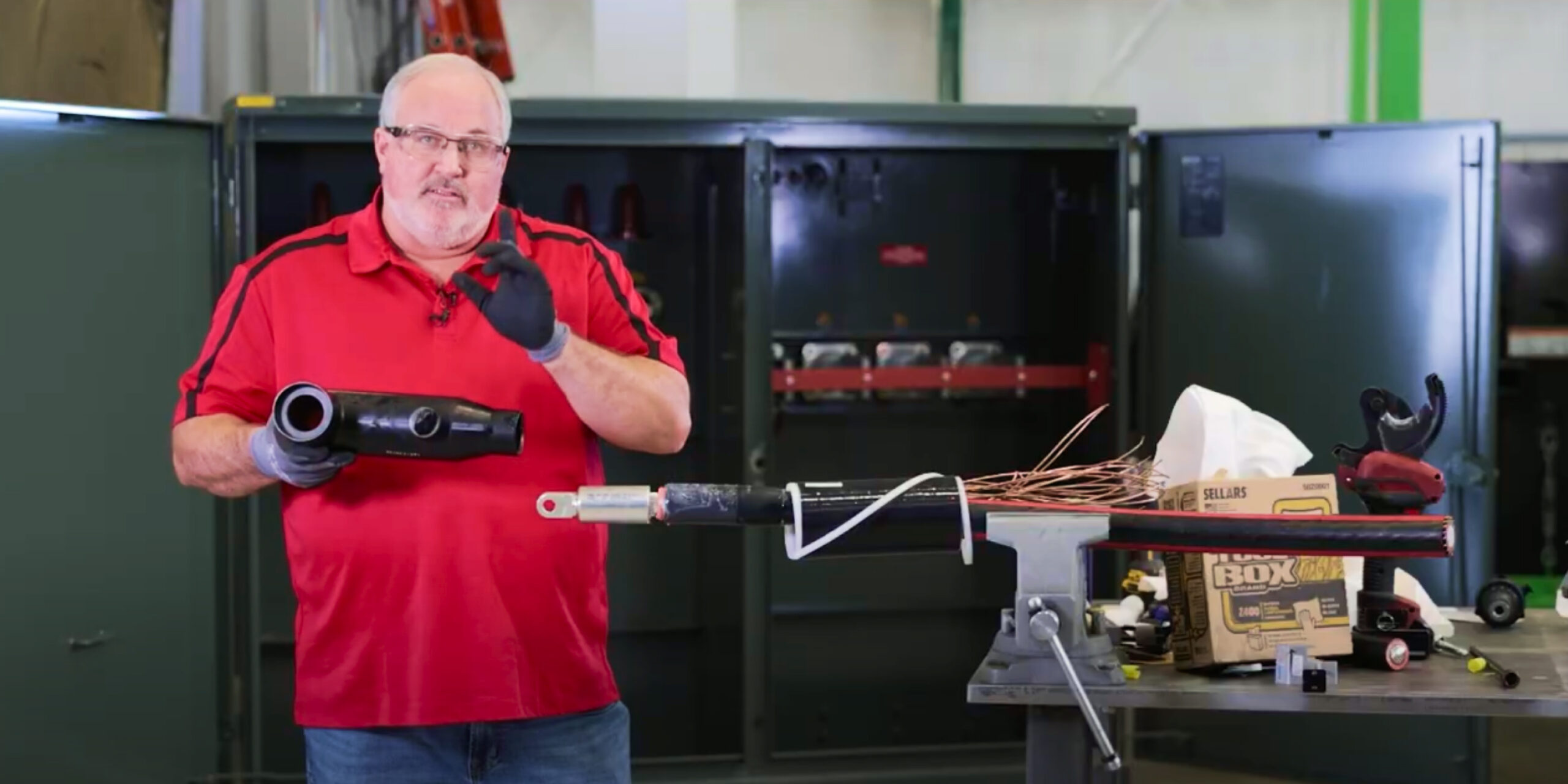 Technician holding a 600 amp T-Body head next to a prepared cable