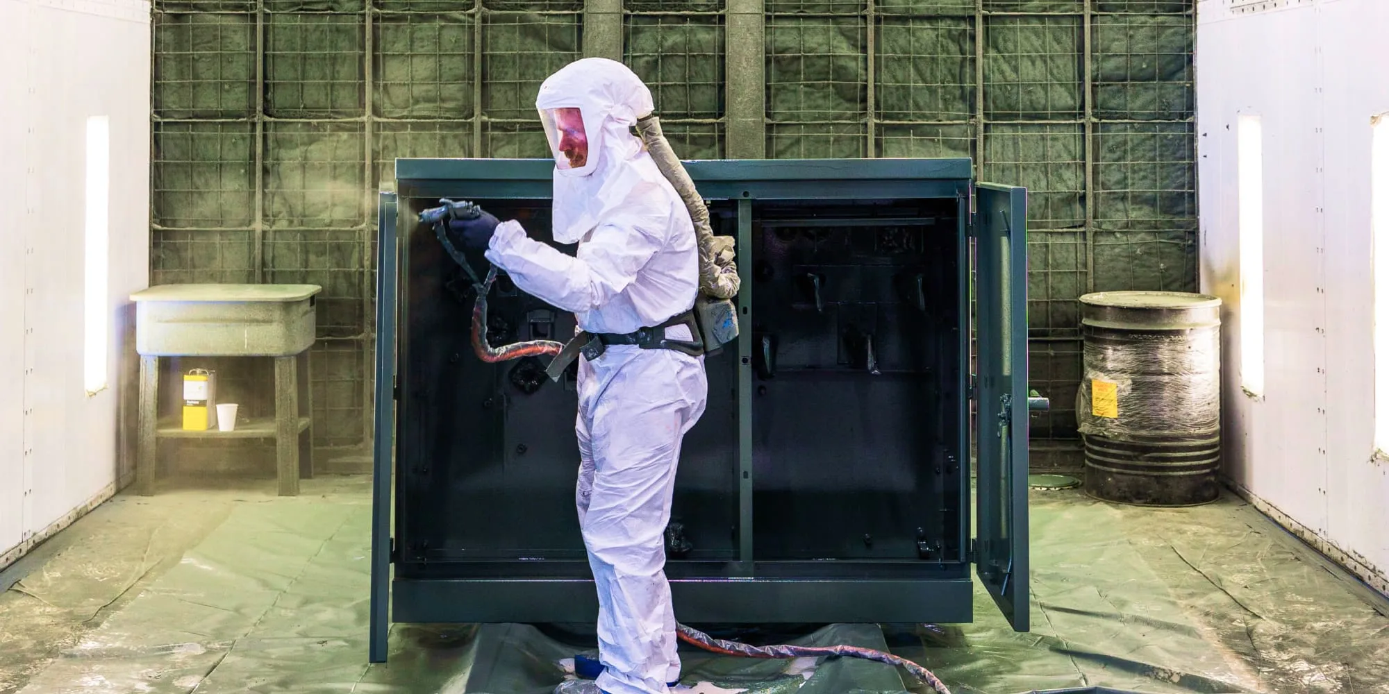 Transformer technician spraying padmount with TransArmour coating